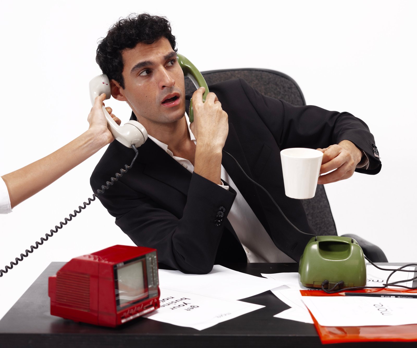 Multitasking media agency professional juggling calls and coffee at retro-themed desk with vintage tech