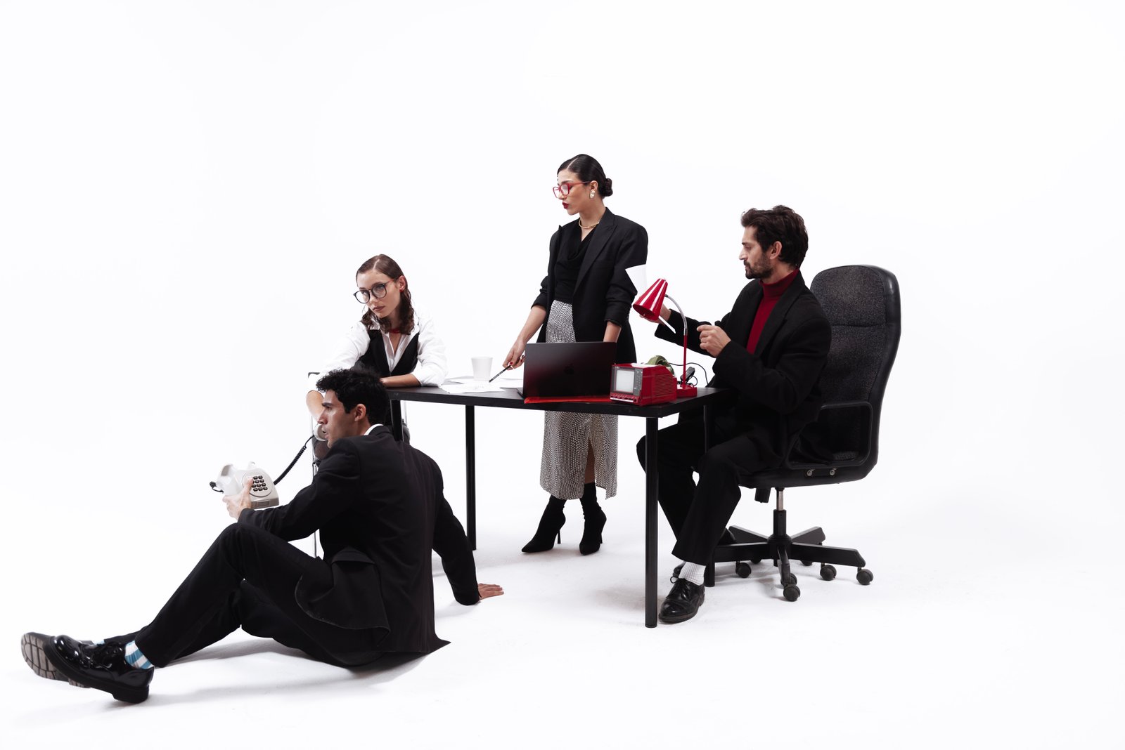 Media agency team collaborating on creative campaign strategy in modern office with laptop, camera, and branding elements